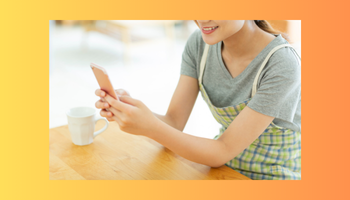 手帳とスマホでスケジュールを管理する女性